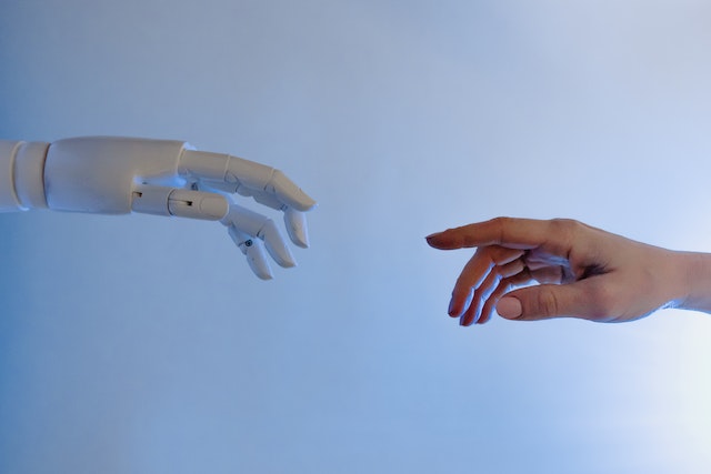 Robot hand and human hand about to touch each other